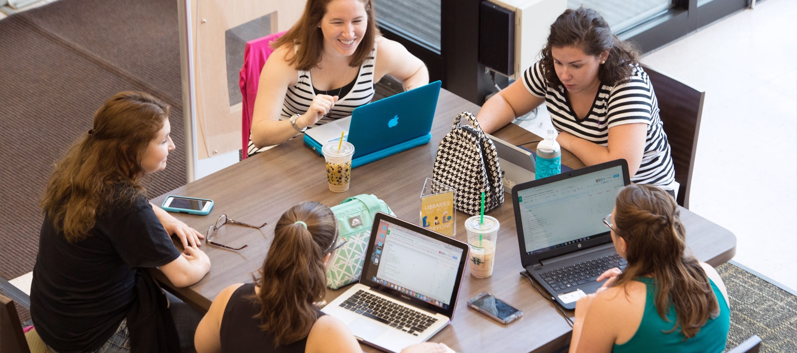 Students with laptops sitting around a table